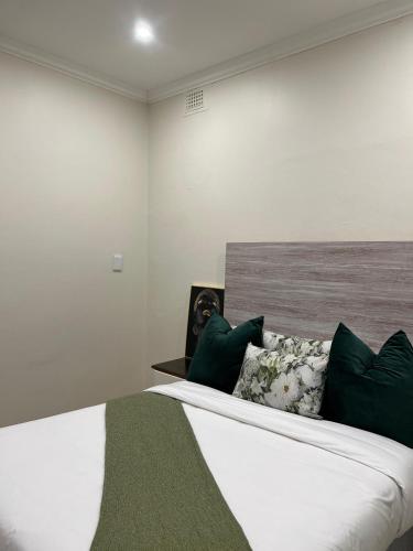 a bedroom with a large bed with green pillows at Montrose BnB in Margate