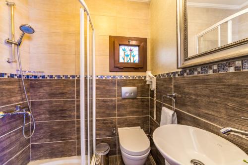 ein Badezimmer mit einem WC, einem Waschbecken und einem Spiegel in der Unterkunft Badem Tatil Evi in Selimiye