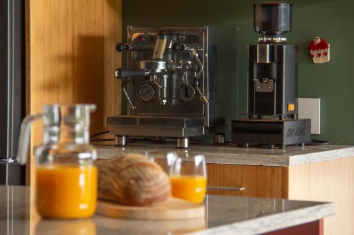a counter with a coffee maker and a plate of orange juice at Woodside Bed and Breakfast in Greytown