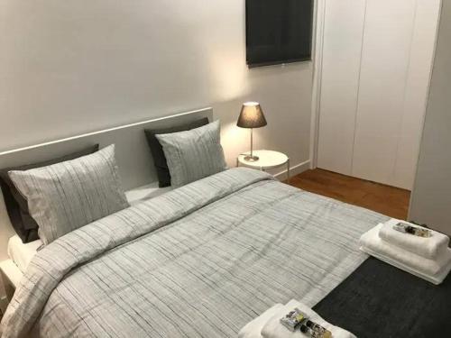 Un dormitorio con una cama grande y una lámpara. en Garcia Place, en Lisboa