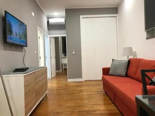 Una sala de estar con un sofá rojo y un televisor de pantalla plana. en Garcia Place, en Lisboa
