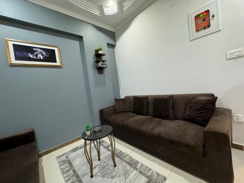 a living room with a brown couch and a table at LUXE 2 BR Apartment Spacious And Modern Lounge in Karachi