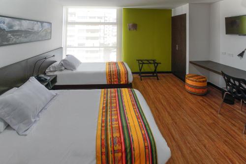 a bedroom with two beds in a room with green walls at Casa Q in Quito