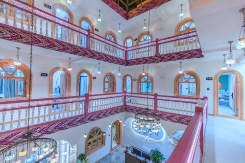 an ornate staircase in a building with arched windows at 红柳花天台花园民宿Red Willow Flower Hotel in Kashgar