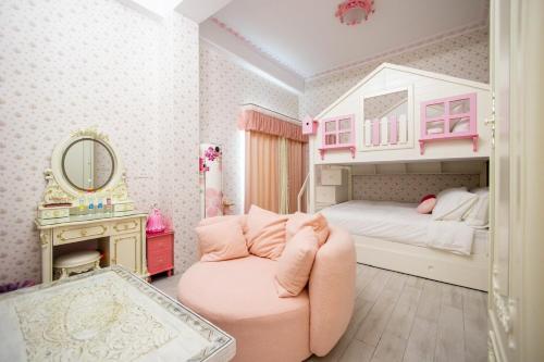 a pink bedroom with a bed and a pink chair at 春漫小築民宿 in Miaoli