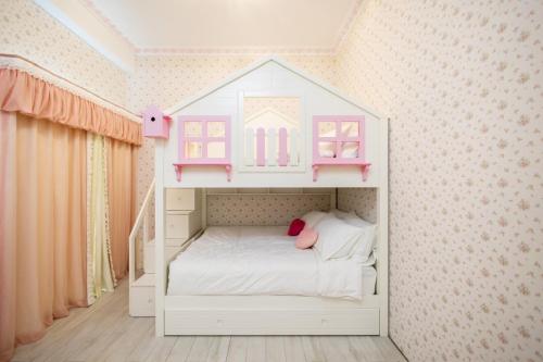 a childs bedroom with a white bed with a house on it at 春漫小築民宿 in Miaoli