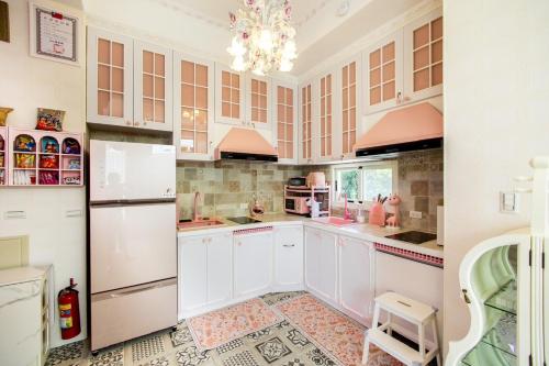 a kitchen with white cabinets and a chandelier at 春漫小築民宿 in Miaoli