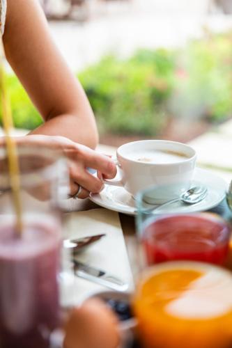 a person sitting at a table with a cup of coffee at Re Ottone Rooms in Lazise