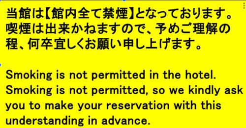 a yellow sign with the words smoking is not permitted in the hotel at Tabist Nisseiya Beppu Kannawa in Beppu