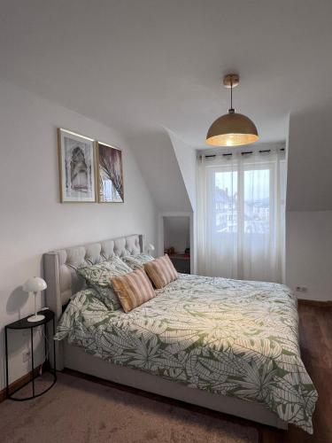 une chambre avec un lit et une fenêtre dans l'établissement Cœur de ville, à Quimper