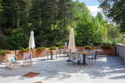 a patio with tables and chairs and umbrellas at Grande Cote Room and Breakfast in Cesana Torinese