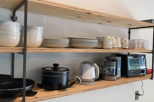 a kitchen shelf with dishes and utensils on it at 藤田別荘 in Shodoshima