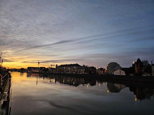 a view of a river at sunset with a city at peniche logement in Creil