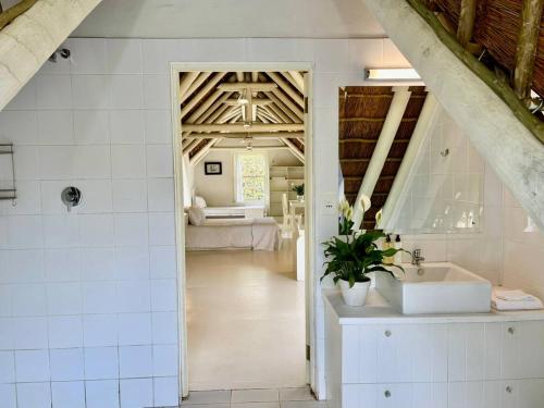a bathroom with a sink and a room with a bed at Kloofzicht Estate Country House in Tulbagh