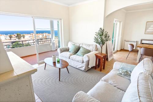a living room with a couch and a table at Vila Agora Luz in Luz