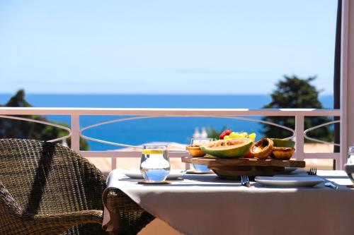 Una mesa con un plato de comida en un balcón. en Vila Agora Luz, en Luz