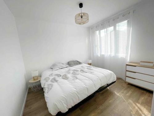 une chambre blanche avec un lit et une commode dans l'établissement T2 plein centre avec stationnement, à Bourgoin-Jallieu