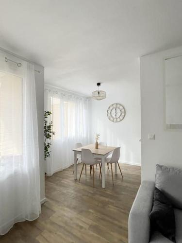 un salon blanc avec une table et des chaises dans l'établissement T2 plein centre avec stationnement, à Bourgoin-Jallieu