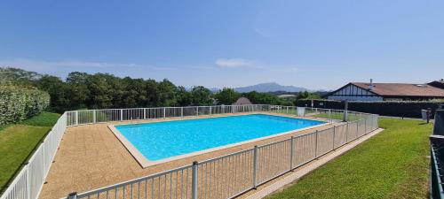une piscine entourée d'une clôture dans l'établissement Lodge Terre de Glisse, à Saint-Jean-de-Luz