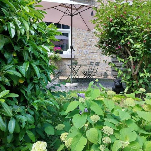 a garden with a table and an umbrella at Monsieur Michel in Dinant