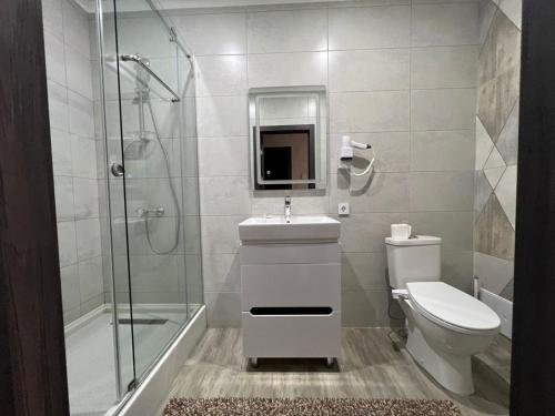 a bathroom with a toilet and a sink and a shower at Meridian in Karagandy