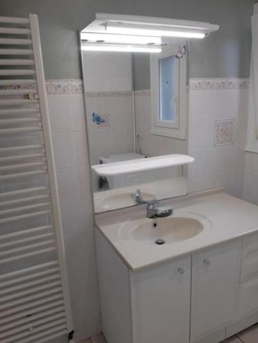 une salle de bain blanche avec un lavabo et un miroir dans l'établissement Maison de campagne, proche plage, à Offrethun