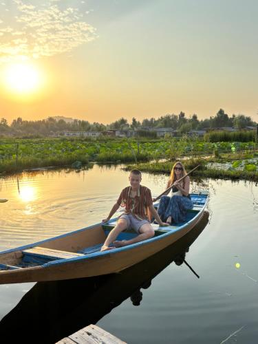 two people sitting in a boat on the water at Houseboat young wild Rose in Srinagar
