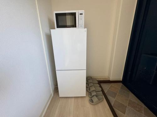 a white refrigerator with a microwave on top of it at プレストスクエア松島町 in Takamatsu