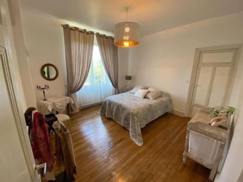 une chambre avec un lit et une fenêtre dans l'établissement Bourgogne grande maison avec jardin à la française, à Pontailler-sur-Saône
