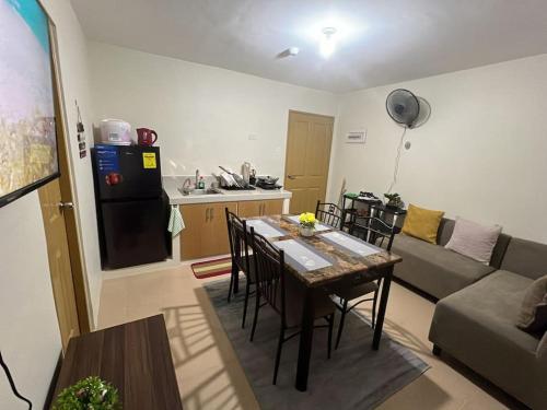 Una cocina y una sala de estar con mesa y sillas. en Maltuae Condotel, en Davao City