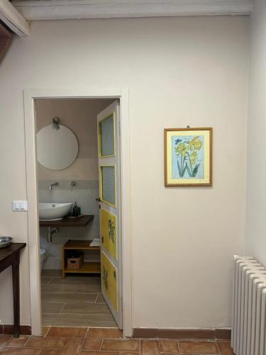 a bathroom with a door leading to a sink at Agriturismo Cascina degli Ulivi in Novi Ligure