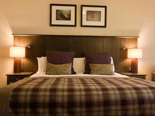 a bedroom with a large bed with two lamps at The Loans Inn in Troon