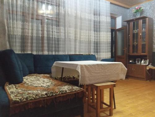 a living room with a blue couch and a table at Fun at the foot of the mountain in Kiş