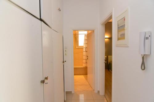 a hallway with a white door leading to a bathroom at Athenian Riviera Varkiza next to the beach in Vari