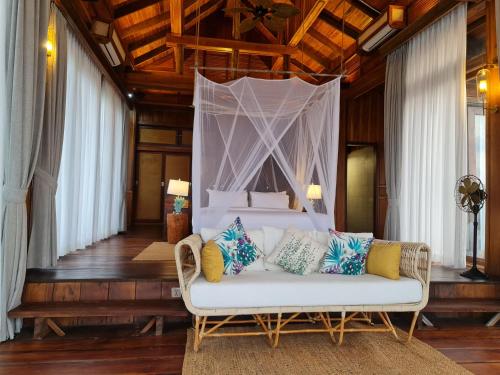 a bedroom with a bed with a white couch at Full Moon Island Resort in Kaoh Sdach