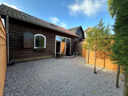 a house with a gravel driveway in front of it at De Voorschuur in Lunteren