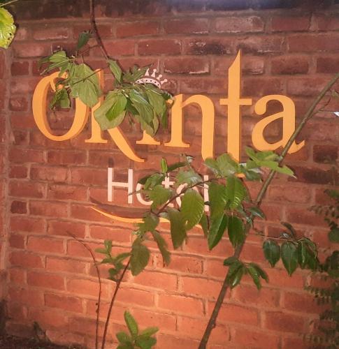 アヌラーダプラにあるOkinta Hotelのレンガの壁と「カフェ」の看板