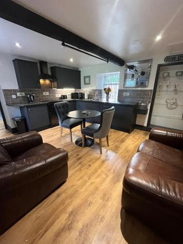 a living room with a couch and a table and chairs at Stepping Stones Cottage in Lealholm