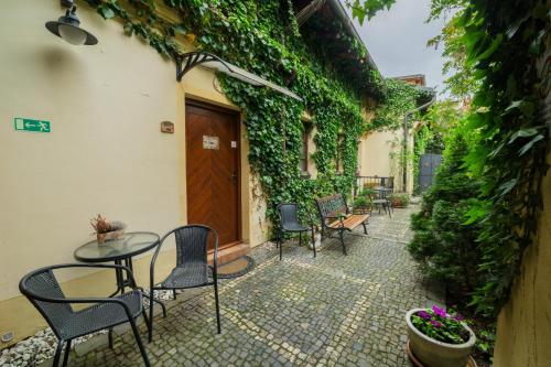 an outdoor patio with chairs and tables and plants at Penzion U Zámku in Mělník