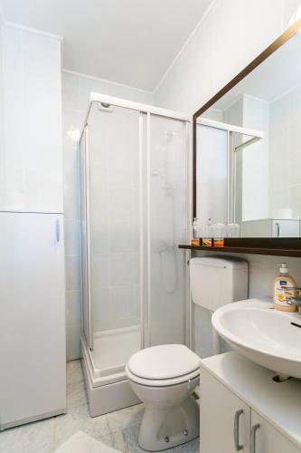 a bathroom with a shower and a toilet and a sink at Apartments Josip in Pinezici