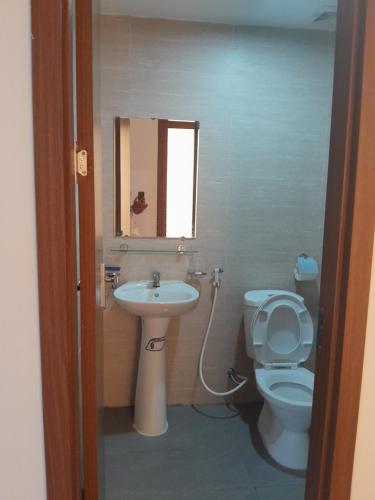 a bathroom with a sink and a toilet and a mirror at Nhà nghỉ 79 in Ðình Loan