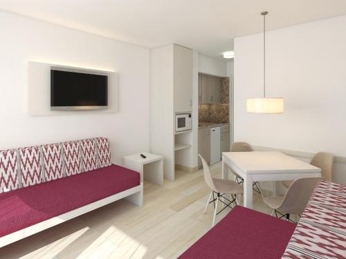 a living room with a couch and a table with a dining room at Apartaments Ses Dàlies in Port d'Alcudia