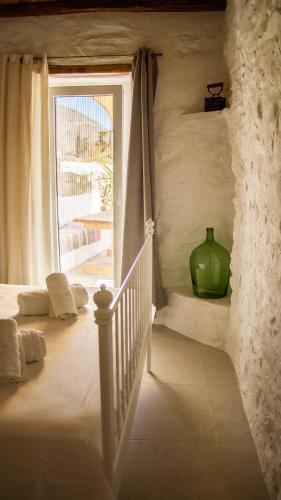 a staircase with a green vase sitting next to a window at A Casa d Irene 2 in Kampos Paros