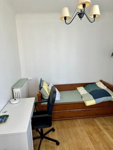 a bedroom with a bed with a desk and a chair at Appartement moderne entier Paris-le Bourget et CDG in Le Bourget