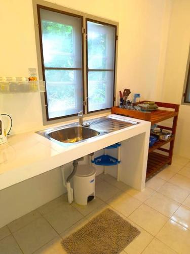 a kitchen with a sink and two windows at Garden Home 6 in Ko Phangan