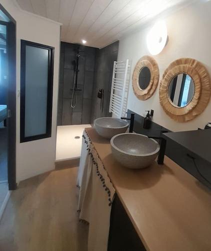 a bathroom with two sinks on top of a counter at Maison 4pers avec jacuzzi privatif couvert proche ocean in Brem-Sur-Mer