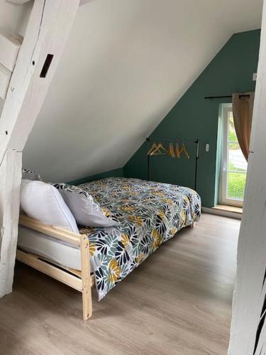 une chambre avec un lit dans un grenier dans l'établissement Petite maison de bourg, à Noyers