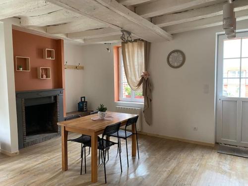 une salle à manger avec une table et des chaises et une cheminée dans l'établissement Petite maison de bourg, à Noyers