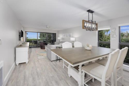 a dining room and living room with a table and chairs at Pelicans Roost 101 condo in Sanibel