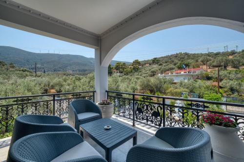 a balcony with chairs and a table and a view at Green Poetree Houses in Galatas